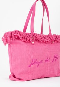 Lyserød tote taske lavet af tekstureret stof med frynset topkant. Har matchende læderhåndtag og broderet "Playa del Mar" design.