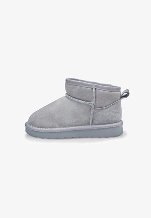 Bottine en suède gris clair avec semelle épaisse, coutures visibles et languette à l'arrière, visible de profil sur fond blanc.