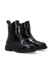 Zwarte glanzende leren enkellaarsjes met twee zijknippers, ronde neus, afgebroken neusstijl en een lage gestapelde hak.