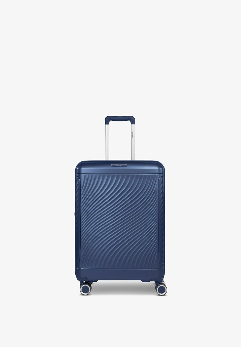 Maleta rígida de color navy con una superficie texturizada ondulada, mango telescópico y cuatro ruedas, diseñada para ofrecer durabilidad y movilidad.