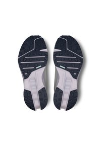 Shoe soles with a textured black rubber tread, curved shape, and light gray accents; designed for grip and durability.