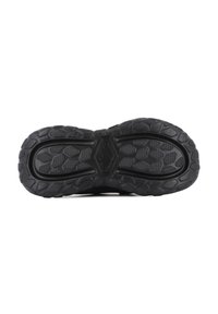 Black athletic shoe sole featuring patterned rubber for grip, textured areas, and a durable design with raised accents for traction.