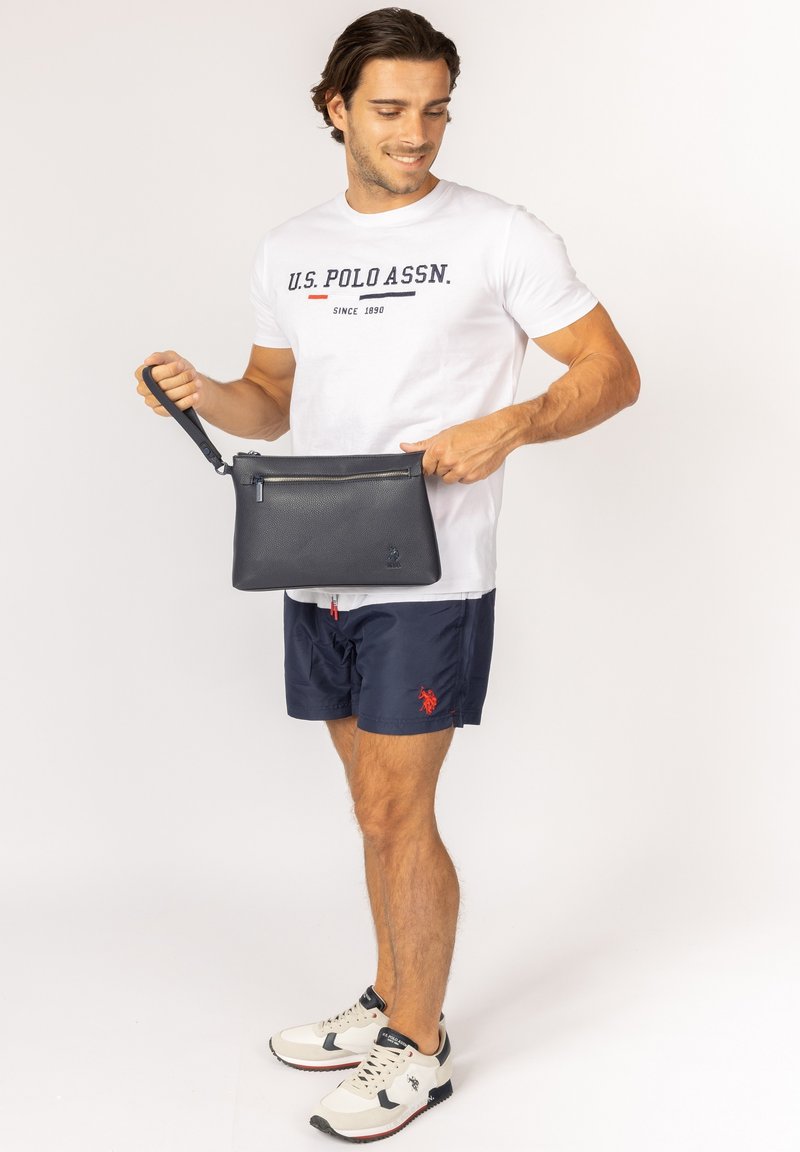 Svart skinnkuvertväska med dragkedja och handrem; texturerad yta; metallisk dragkedjedetalj längst upp.