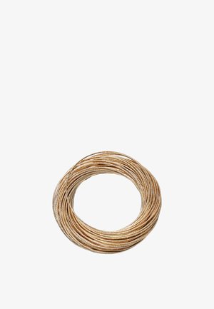 Zvinutý zväzok tenkého medeného drôtu na bielom pozadí.