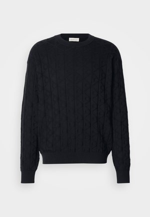 Czarny sweter z dzianiny z wzorem w romby, okrągłym dekoltem oraz ściągaczami przy mankietach i dolnej krawędzi. Wykonany z miękkiego, ciepłego materiału.