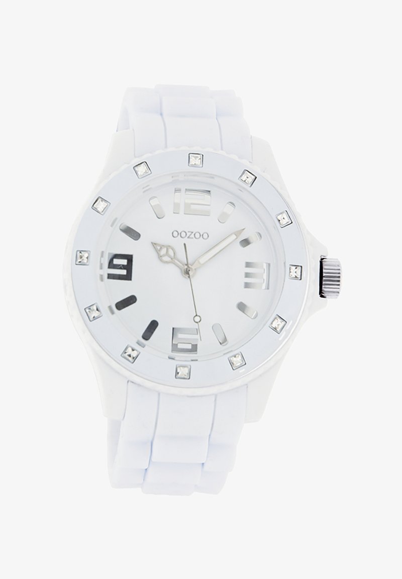 Montre en silicone blanche avec un cadran rond, accents argentés, marqueurs transparents et cristaux décoratifs autour de la lunette. Dotée d'un bracelet texturé.