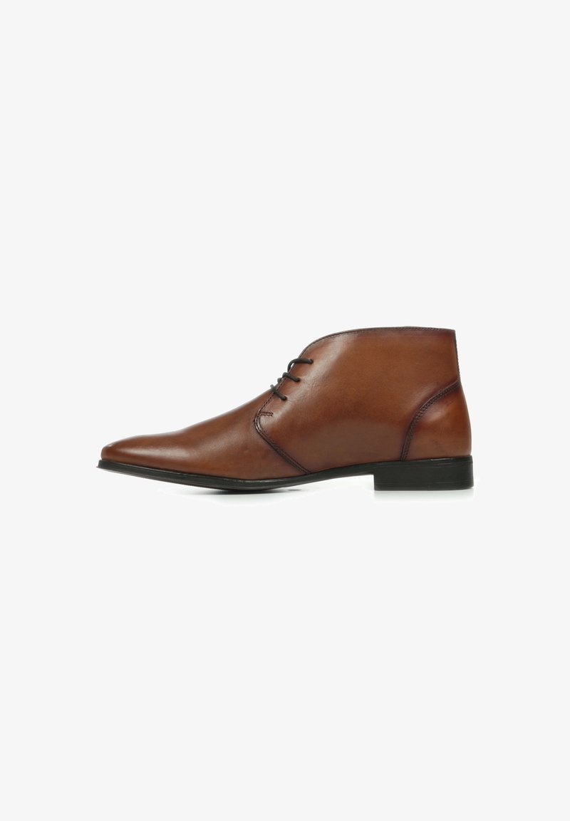 Bottines en cuir marron avec un bout pointu, deux œillets pour les lacets et un talon bas rectangulaire. Texture lisse avec un minimum de coutures.