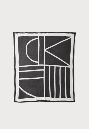 Black and white patterned textile featuring geometric shapes and lines, with a textured surface and contrasting borders.