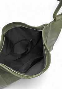 Sac à main en cuir vert olive avec un extérieur texturé, une fermeture éclair et un intérieur en tissu noir. Comprend une poche zippée intérieure pour l'organisation.