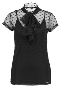 Blusa negra de manga corta, con una tela transparente con patrón de estrellas, un lazo en el cuello y una silueta ajustada.
