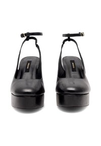 Czarne skórzane buty na platformie z otwartym tyłem, cienkim paskiem wokół kostki i grubym obcasem. Gładka tekstura i minimalistyczny design.