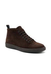 Stivaletti in suede marrone con punta tonda, allacciatura frontale e linguetta nera sul tallone. La suola è resistente, offrendo aderenza e supporto.