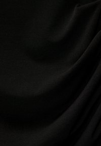 Zwarte stof met een gladde, matte textuur, die subtiele draping en variatie in lichtreflectie vertoont. Geen duidelijke patronen of ontwerpen.