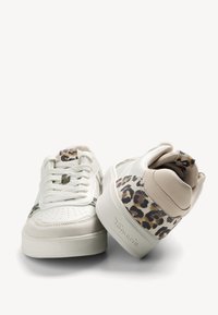 Bílé tenisky s hladkým koženým svrškem, které mají leopardí potisk na patě a na boku. Texturovaná podrážka a šněrovací design.