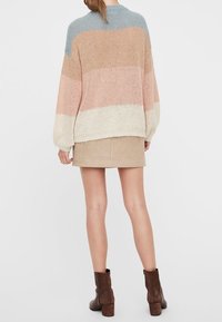 Maglione lavorato a maglia con vestibilità ampia, caratterizzato da righe orizzontali nei colori blu, pesca e crema. Abbinato a una minigonna beige e stivali marroni.