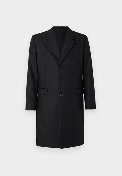 Musta räätälöity takki, jossa on lovikaulus, kaksi etutaskua, yhden napin kiinnitys ja kolme nappia. Sileä kangas, jossa on laadukas viimeistely.