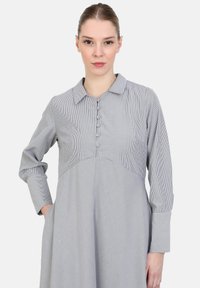Pruhované šedobílé šaty s dlouhými rukávy, s límečkem, knoflíkovým zapínáním a kapsami, s rozšířeným siluetou.