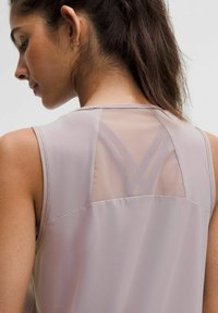Débardeur sans manches en mauve clair avec un panneau arrière en maille transparente présentant un motif en croix. Tissu lisse, coupe décontractée, coutures détaillées.