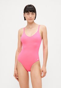 Costume da bagno rosa brillante con scollo a v, spalline sottili regolabili e texture liscia. Presenta un piccolo logo Nike bianco in basso a destra.