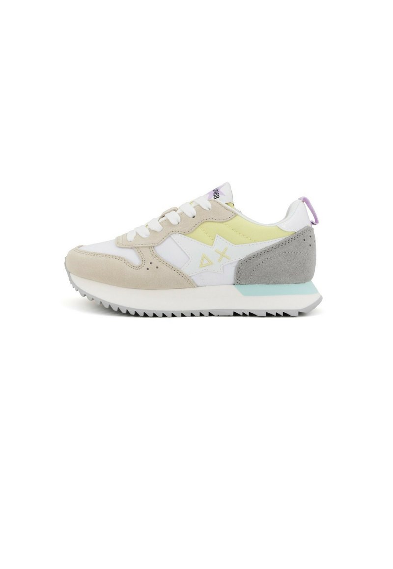 Sneaker mit einem beige-weißen Obermaterial, gelben Akzenten, einer grauen Wildleder-Ferse und einer strukturierten weißen Sohle mit Profilmustern.