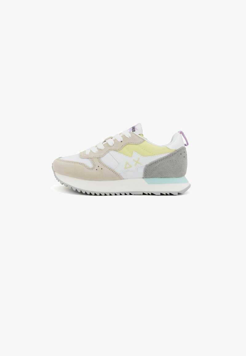 Sneaker mit einem beige-weißen Obermaterial, gelben Akzenten, einer grauen Wildleder-Ferse und einer strukturierten weißen Sohle mit Profilmustern.