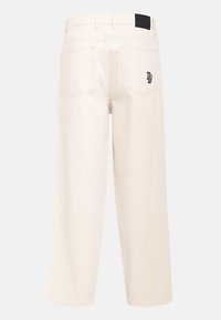 Pantalons larges beige clair avec une taille haute. Présente une étiquette noire à l'arrière et deux poches plaquées. Fabriqués en denim.