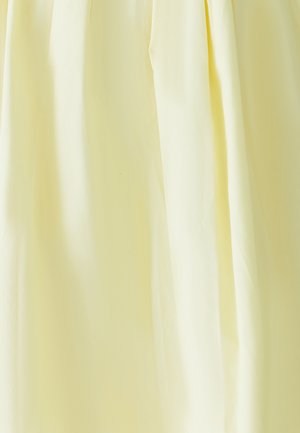 Tissu jaune clair avec une texture lisse, présentant un drapé doux et un éclat subtil. Pas de motifs ni de détails matériels visibles.