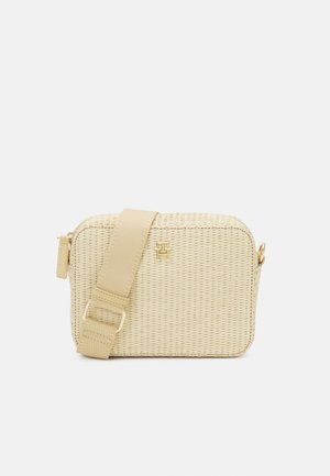 Beige geweven crossbodytas met een rechthoekige vorm, gouden logo aan de voorkant en verstelbare brede stoffen riem met gesp.