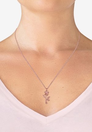 Halskette aus Roségold mit einem floralen Anhänger, der eine Rose und Blätter darstellt, an einer filigranen Kette, vor einem hellen Oberteil.
