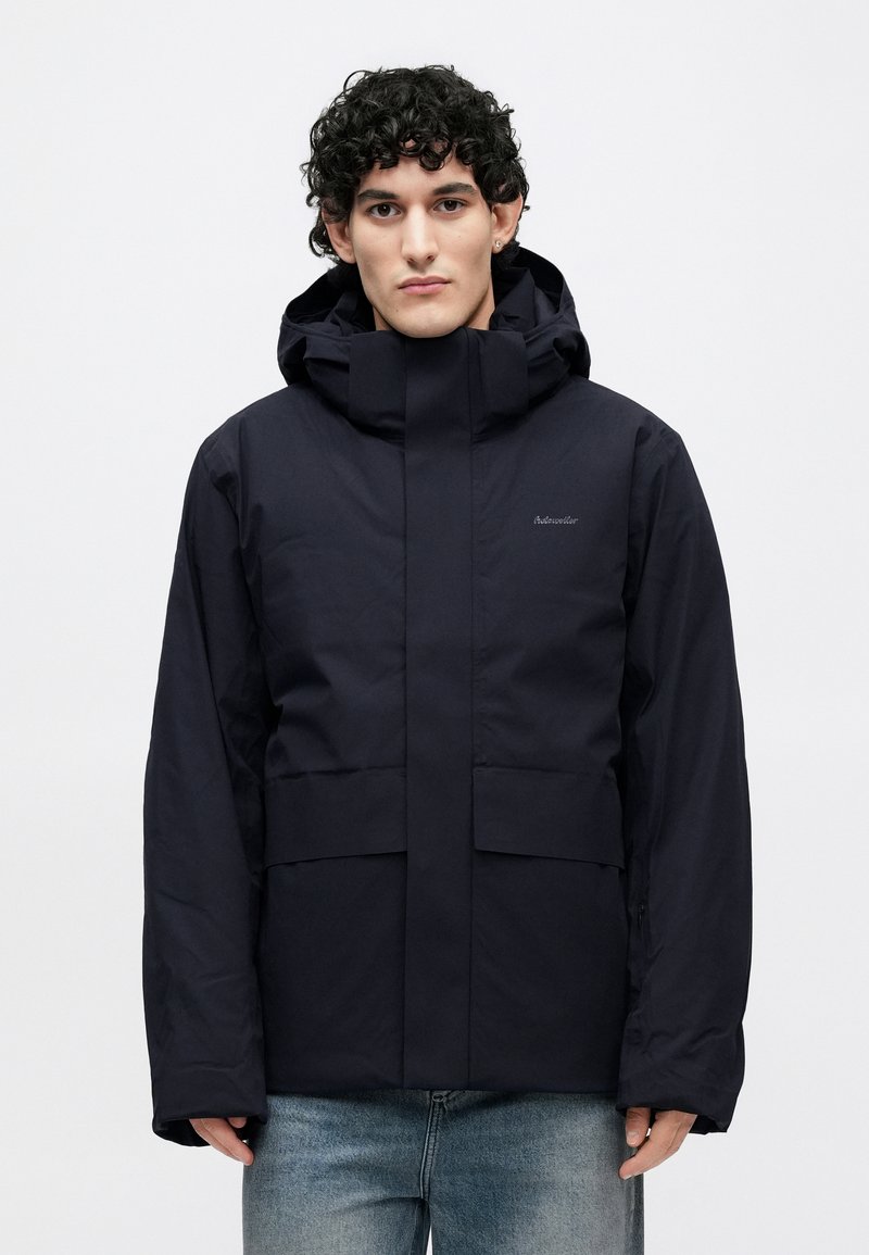 Navy blue waterproof jacket with a high collar, hood, and front pockets. Features a smooth texture and minimalistic design.