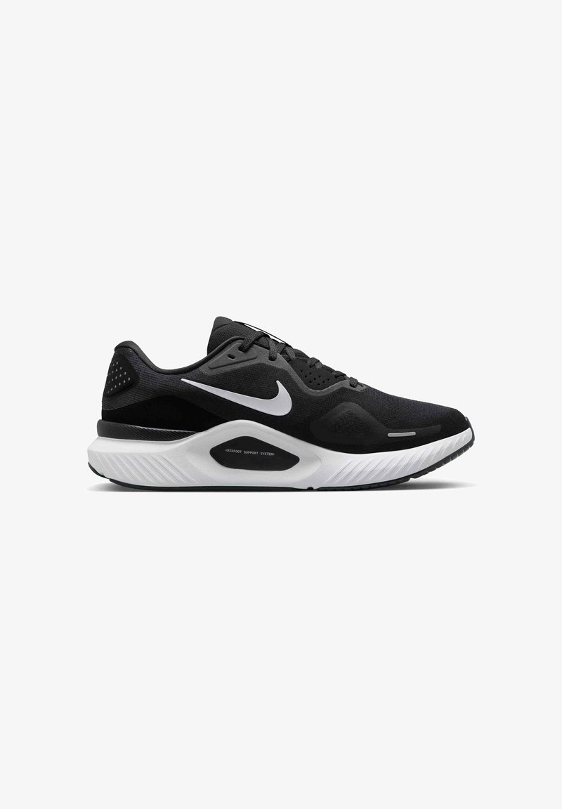 Chaussure de sport noire avec tige texturée, logo swoosh blanc, semelle intermédiaire blanche rembourrée et semelle extérieure en caoutchouc pour l'adhérence.