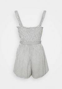 Zwart-wit geruite romper met brede bandjes, gerimpelde halslijn, getailleerde taille en losse shorts. Zachte, lichtgewicht stof.