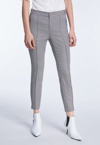 Gecontroleerde zwart-wit slim-fit broeken met een gladde textuur, voorzien van zijritsen bij de enkels en een hoog tailleontwerp.