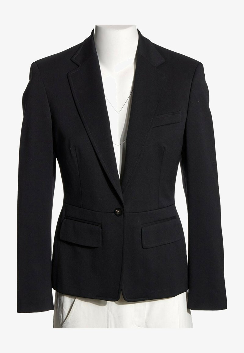 Blazer noir cintré à un seul bouton avec revers crantés, poches à rabat et coupe slim sur un buste de mannequin blanc.