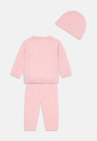 Pink knitted children's outfit featuring a cable knit pattern. Includes a long-sleeve sweater, matching pants, and a soft beanie.