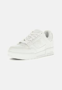 Sneaker bianco in pelle con accenti testurizzati, punta arrotondata, colletto imbottito e lacci piatti. Presenta un dettaglio del logo sul lato e suola in gomma.