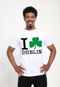 White cotton t-shirt featuring "I ♥ DUBLIN" in black and green, with a green shamrock design. Short sleeves and relaxed fit.