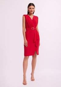 Czerwona sukienka do kolan z zapinanym fasonem, krótki rękaw, talia z paskiem z złotą klamrą oraz drapowaną przodem z rozcięciem po boku.