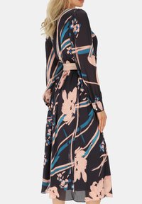 Kwiatowa sukienka midi w kolorze czarnym z różowymi i niebieskimi wzorami. Posiada długie rękawy, talię podkreśloną gumką oraz zwiewny materiał z delikatną fakturą.