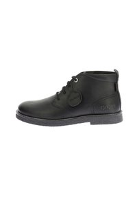 Stivaletti in pelle nera con punta rotonda, design con lacci, suola texturizzata e un'etichetta con il logo Kickers sul lato.