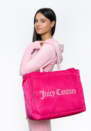 Rosa Nylon-Shopper-Tasche mit weißem "Juicy Couture"-Logo, ausgestattet mit doppelten Tragegriffen und einer Reißverschlusstasche an der Vorderseite. Glatte Textur und gepolstertes Design.