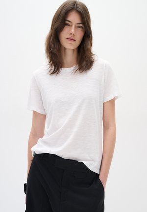 White short-sleeve T-shirt made from lightweight fabric with a soft texture. Features a classic round neckline and a relaxed fit.