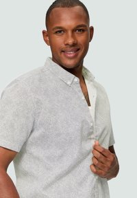 Korte mouwen button-up shirt in lichtgrijs met een meshpatroon, voorzien van een kraag en een enkele borstzak. Gladde textuur.