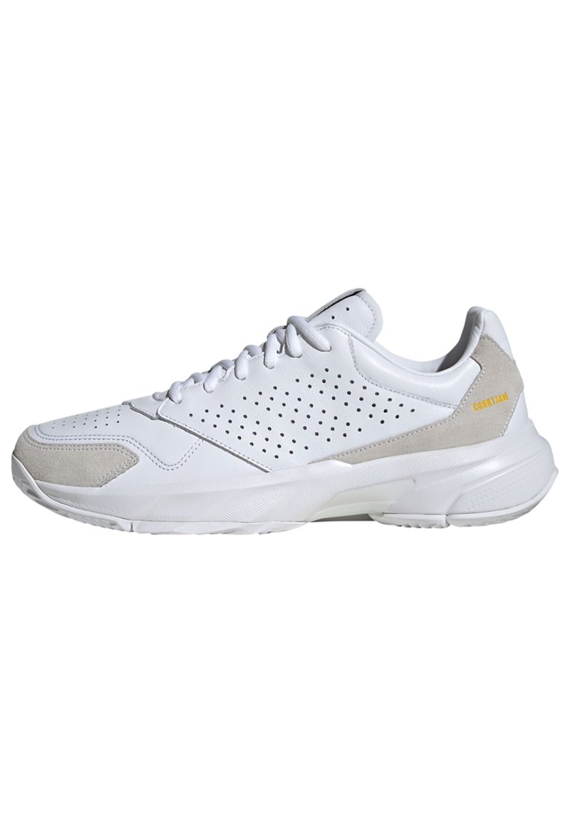 Chaussure de sport blanche avec tige en cuir perforé et accents en suède beige. Dispose d'un col rembourré, de lacets et d'une semelle texturée.