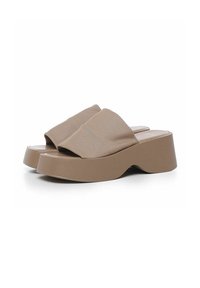Beige platform slip-on sandaler med et polstret tekstiloverflade, en rundt tåform og en tyk sål med et bølget design.