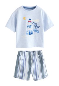 Světle modrá košile s krátkým rukávem s majákem a textem "lighthouse vibes", doplněná modro-bílými vertikálně pruhovanými šortkami.