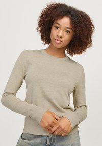 Beige Langarmpullover mit Rundhals-Ausschnitt, gerippten Bündchen und Saum; aus einem weichen, strukturierten Strickstoff gefertigt.
