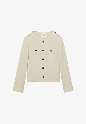 Veste beige raccourcie en tissu texturé, avec un col rond, deux poches poitrine et des boutons noirs sur le devant.