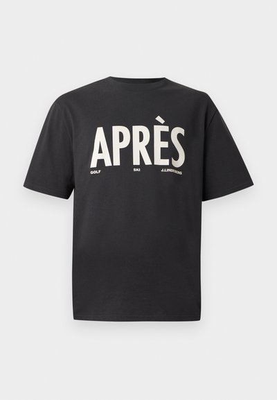 Μαύρη μπλούζα από βαμβάκι με μεγάλες λευκές γραμματοσειρές "APRÈS", με μικρότερες γραμματοσειρές "GOLF" και "SKI" από κάτω. Κλασική στρογγυλή λαιμόκοψη και χαλαρή εφαρμογή.