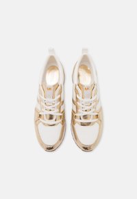 Zapatillas deportivas blancas y doradas con acentos metálicos, material de malla y una puntera texturizada. Sistema de cordones clásico con detalle del logotipo.